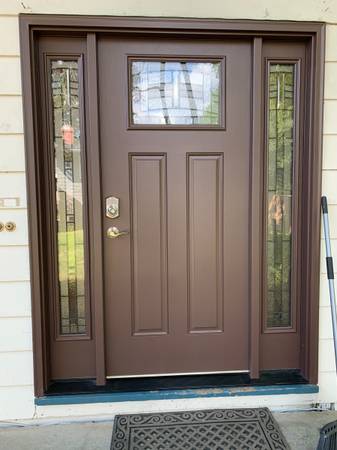 Brown exterior entry door installed with glass sidelights