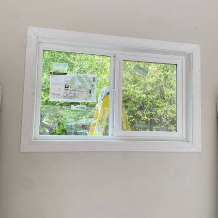 Two white replacement windows installed in a finished room